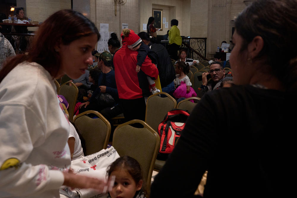 Two women chat as they wait to be assigned to a shelter, in the lobby of the Roosevelt Hotel.