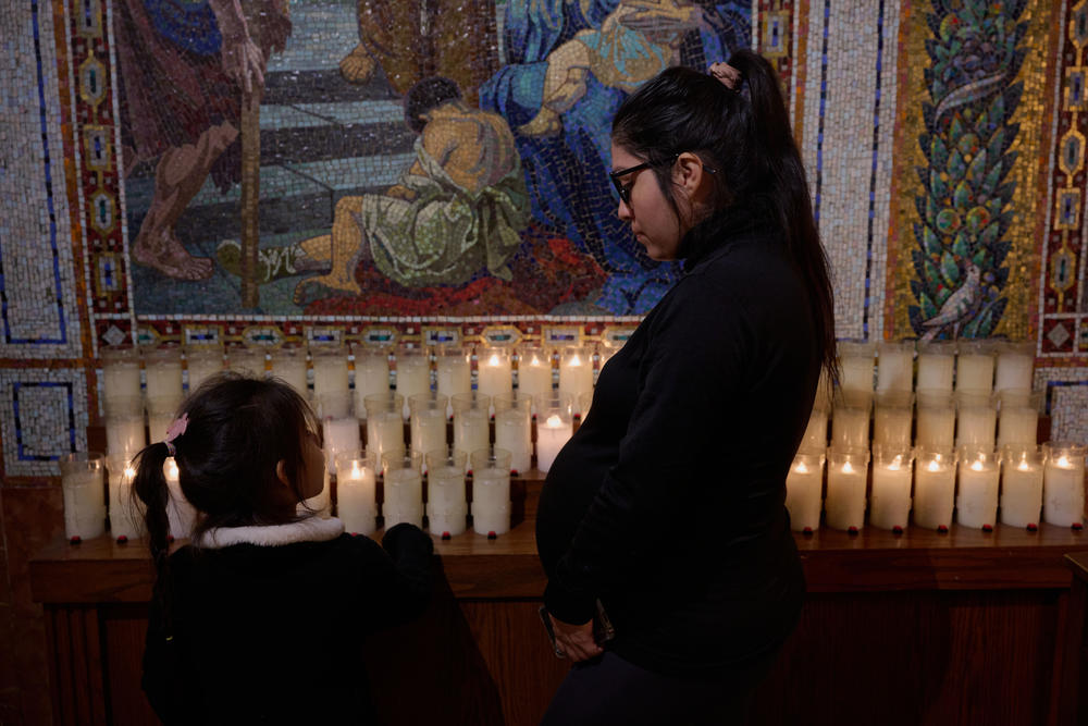 Liz, from Peru, is also a patient at Bellevue's Women's Health Clinic. Here, she explains the lit candles to her daughter in a church in Midtown Manhattan. She doesn't like to leave her room at the hotel, but as her due date nears she tries to get out and walk. Her favorite place to visit is this church, where she hopes to baptize her youngest children.