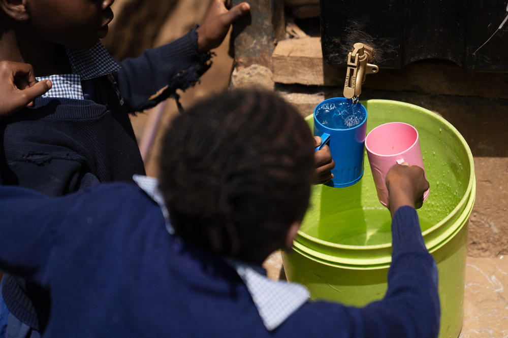 Students at Saint Juliet's fill their cups with water during a break from their exams.<strong> </strong>The water flows out a machine, developed by a company called Majik Water, that pulls water out of the air through a condensation technique.