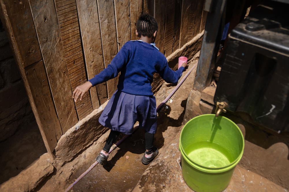 A student at Saint Juliet's primary school in Kibera, Nairobi's largest slum, takes a cup of water back to the classroom with her. The school's water comes from the atmospheric water generator from a nonprofit group called Majik Water<strong>.</strong>