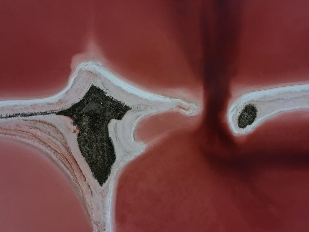Evaporation ponds that are pinkish-red due to high salinity levels are visible on the north section of the Great Salt Lake in August 2021 near Corinne, Utah.