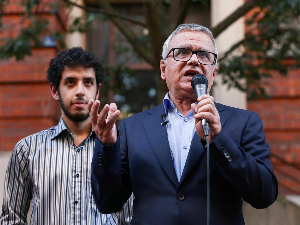 Iranian journalist Taghi Rahmani, husband of Iranian rights campaigner and 2023 Nobel Peace Prize laureate Narges Mohammadi, speaks, flanked by their son Ali, during a press conference in Paris on October 6, 2023.
