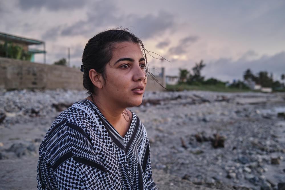 Lauren Rodriguez Ruiz, 26, sits on the beach in the neighborhood where she lives. In the month and a half that her boyfriend, Jan Perez Suárez, was on the way from Cuba, via Nicaragua, El Salvador, Guatemala and Mexico, and via a <em>coyote,</em> or people smuggler, to the U.S., she asked the sea for protection. It was the only place she could rest.