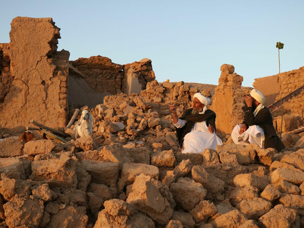 Afghan residents sit at a damaged house after an earthquake in a village in Herat province on Saturday.