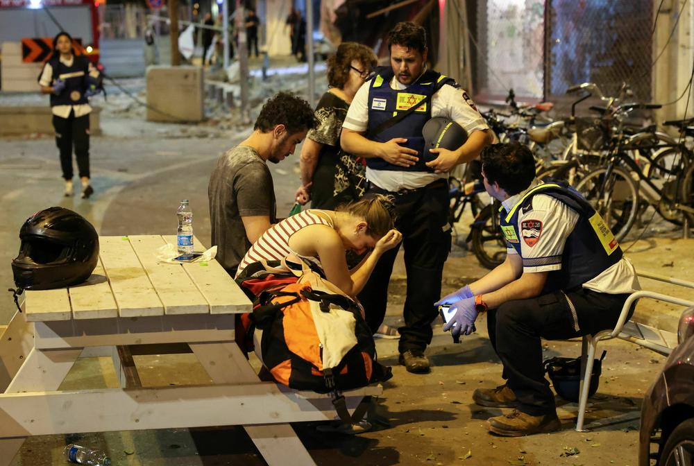 Sat., Oct. 7: A young woman reacts as she speaks to Israeli rescuers in Tel Aviv.