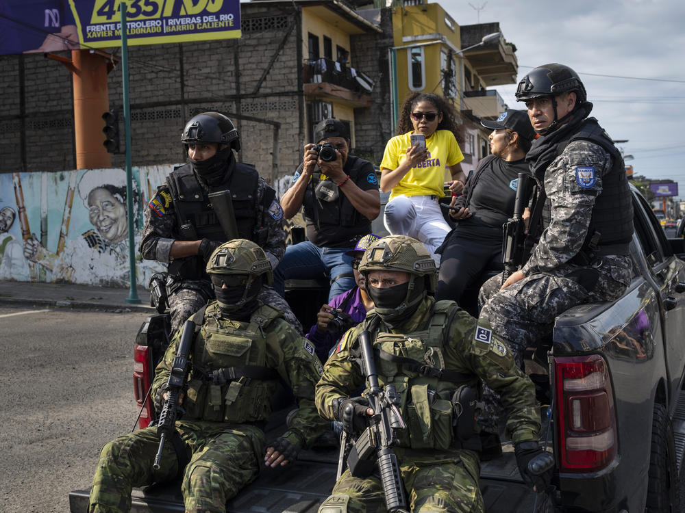 Soldiers patrol from on top of an armored vehicle as supporters of presidential candidate Daniel Noboa, of the National Democratic Action Alliance political party, attend a rally downtown in Esmeraldas, Ecuador, Friday, Oct. 6, 2023.