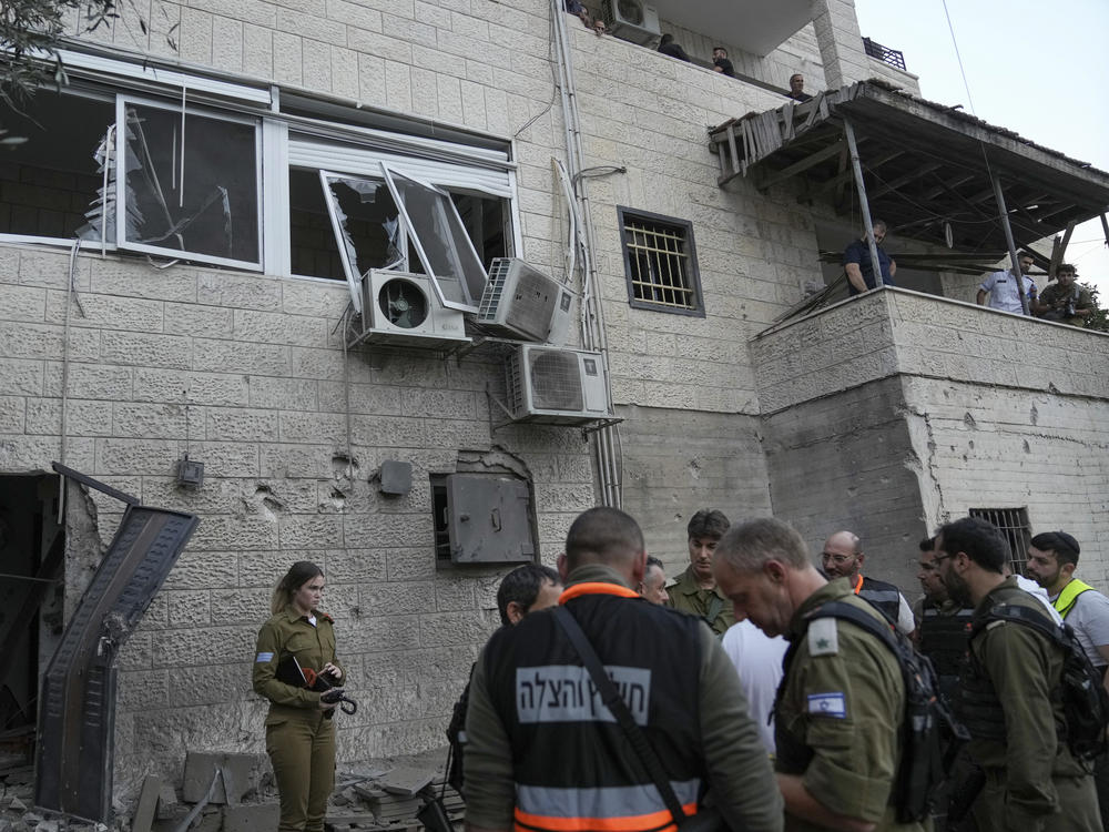 Israeli security forces inspect a damaged house after it was hit by a rocket fired from the Gaza Strip, in the village of Abu Ghosh near Jerusalem, Monday.