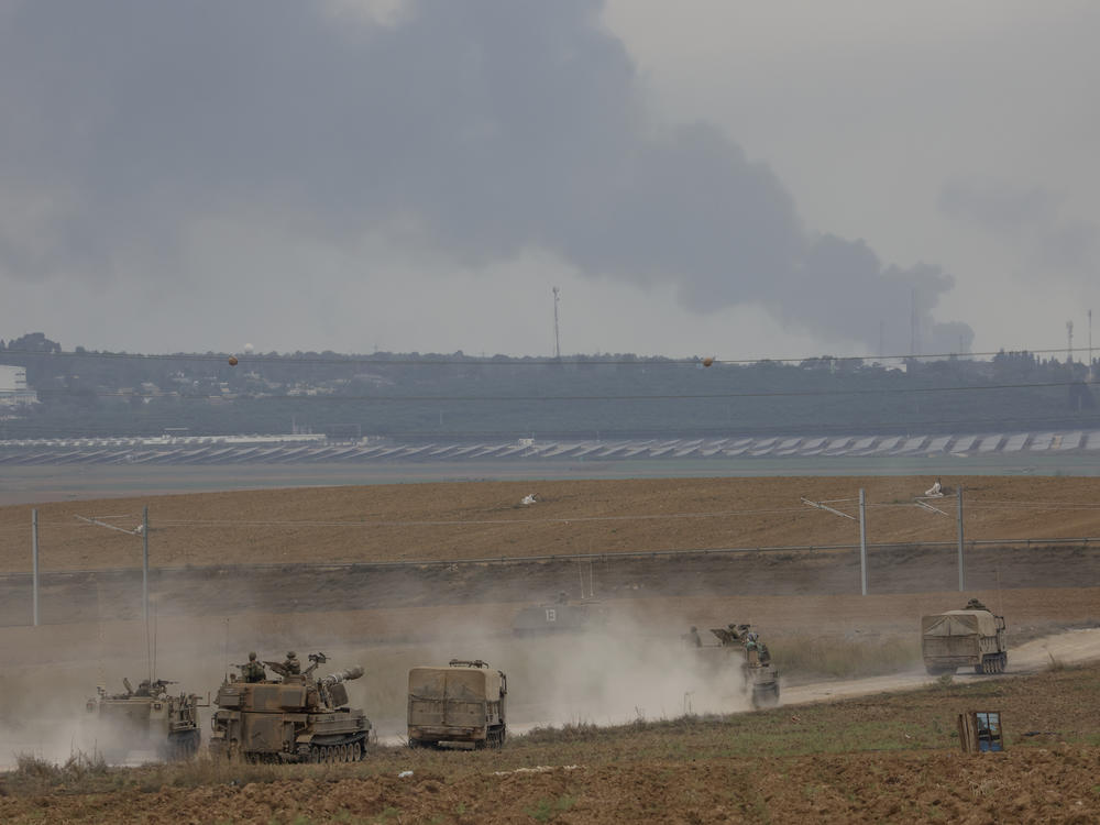 Israeli army vehicles move near the Israeli Gaza border, southern Israel, Monday.