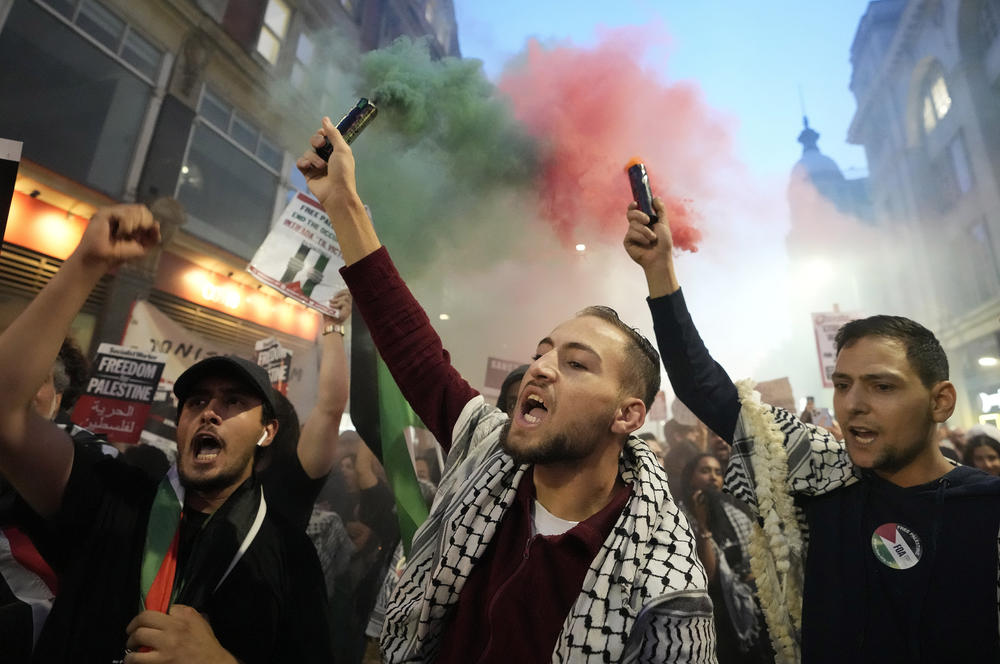 Protesters hold flares during a pro-Palestinian demonstration in London, Monday, two days after Hamas fighters launched an unprecedented, multi-front attack on Israel.