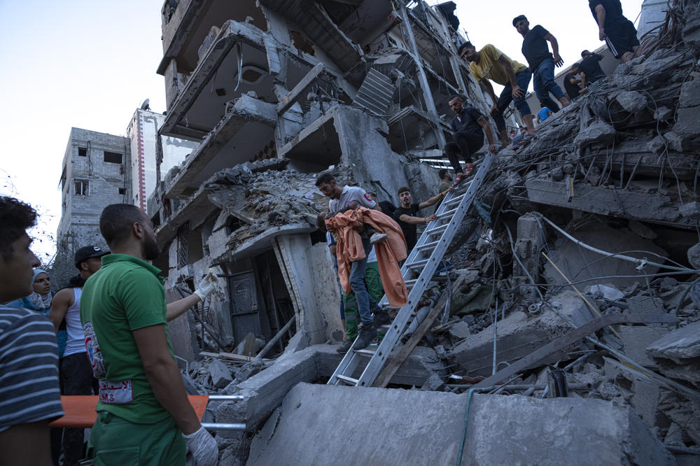 Palestinians rescue a young girl from the rubble of a destroyed residential building following an Israeli airstrike on Tuesday.