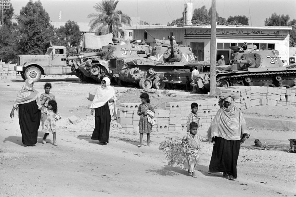 Gazans walk past Israeli army tanks during the Six-Day War in June 1967.