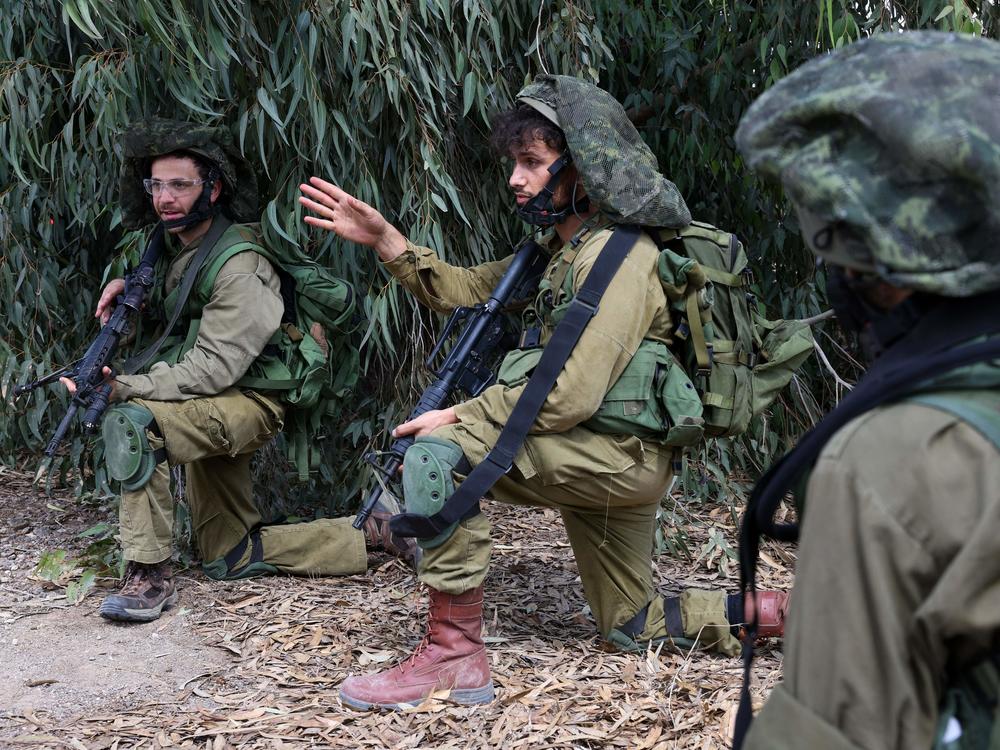 Israeli soldiers take up position in Kfar Aza, in the south of Israel, bordering Gaza Strip on Tuesday, Oct. 10, 2023.