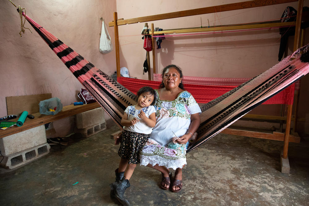 María Enedina Canul Poot, 54, one of the founding members of The Amazonas of Yaxunah, with her granddaughter at their home in Yaxunah, Yucatán, Mexico. Canul Poot played softball as a girl and was thrilled to return to the game years later.