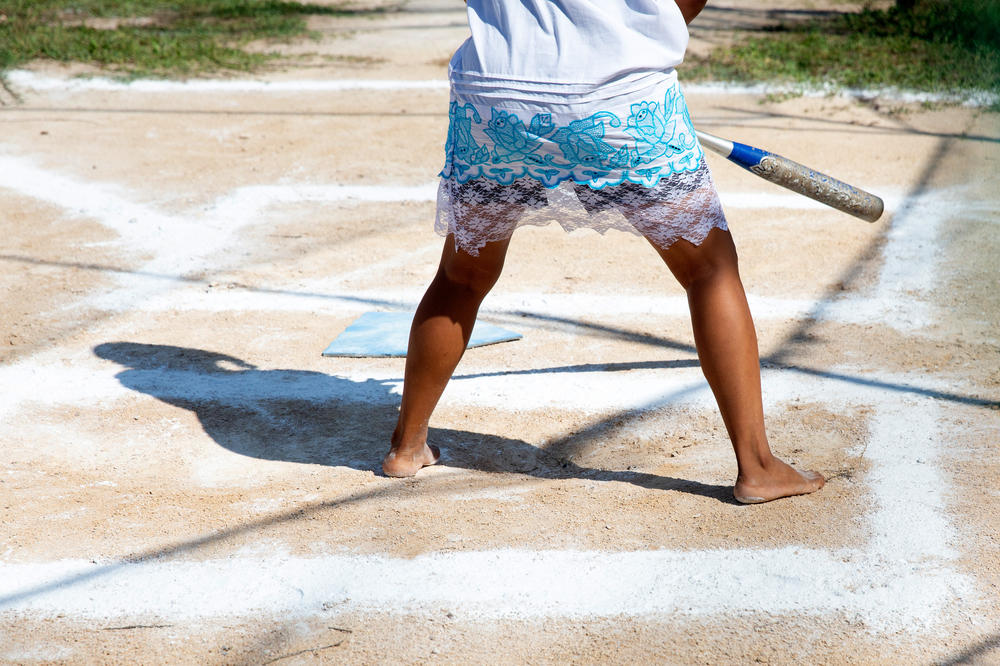 A member of the Amazonas of Yaxunah team takes a barefoot stance as she waits for a pitch. The women on the team play barefoot to show how tough they are — and shrug off the risks.
