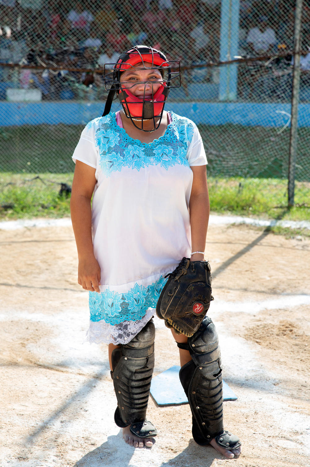 Jazmin Guadalupe Lopez Poot, 17, a player for the Amazonas of Yaxunah team, wears a faceguard with mask and shin pads as she takes on the role of catcher.
