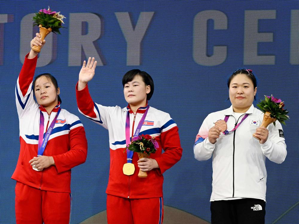 Gold medalist North Korea's Song Kukhyang, center, silver medalist North Korea's Jong Chunhui, left, and bronze medalist South Korea's Kim Suhyeon, right, gesture during the medal ceremony of women's 76kg group A weightlifting competition at the 2022 Asian Games in Hangzhou, China, on Oct. 5, 2023.