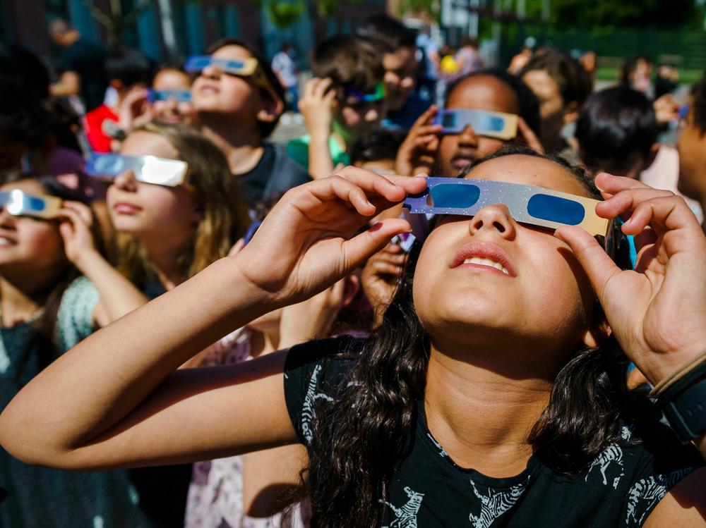 Pupils, wearing protective glasses, look at the partial solar eclipse in Schiedam, the Netherlands, on June 10, 2021.