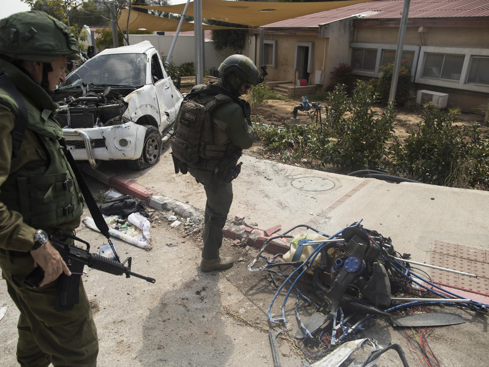 Israeli soldiers inspect the engine from a paraglider that Palestinian militants used a few days earlier in an attack on the Kfar Aza kibbutz near the border with Gaza, on Tuesday, Oct. 10, 2023.