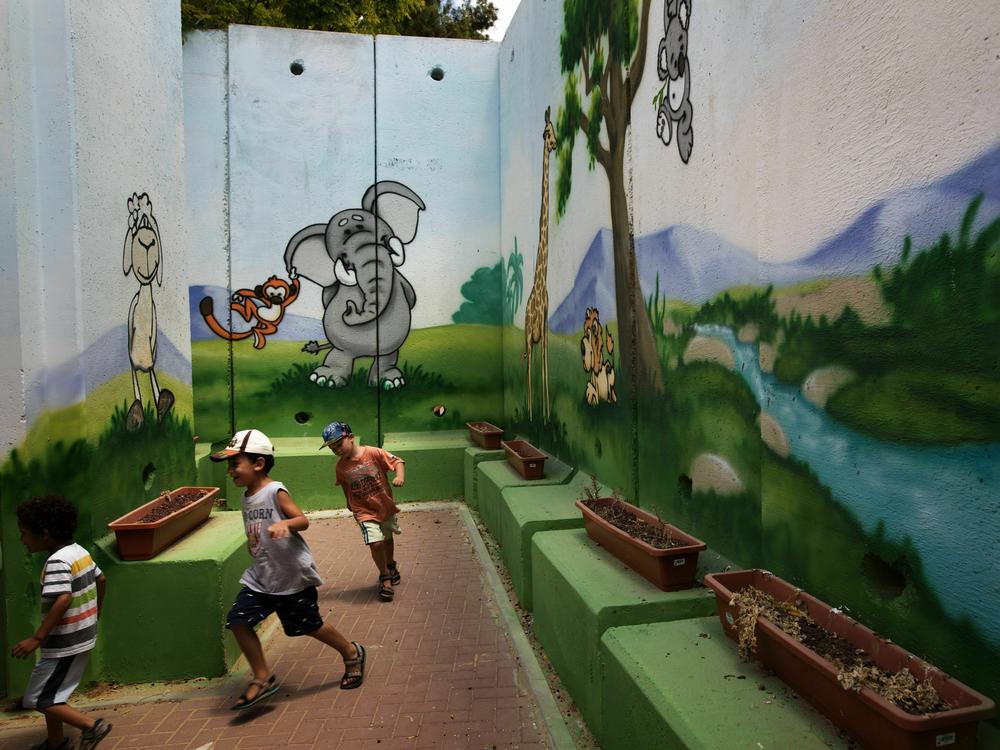 Children play at a kindergarten surrounded by decorated concrete blast walls designed to protect from rocket and mortar fire in 2015 in the southern Israeli Kibbutz of Nahal Oz near the border with the Gaza Strip.