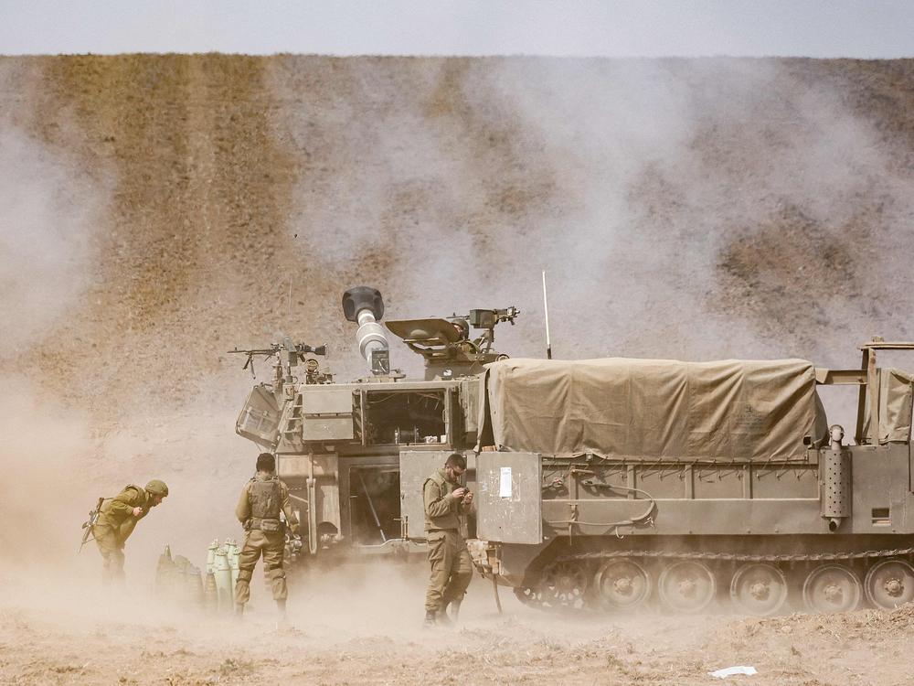 An Israeli army self-propelled howitzer fires rounds near the border with Gaza in southern Israel on Oct. 11.