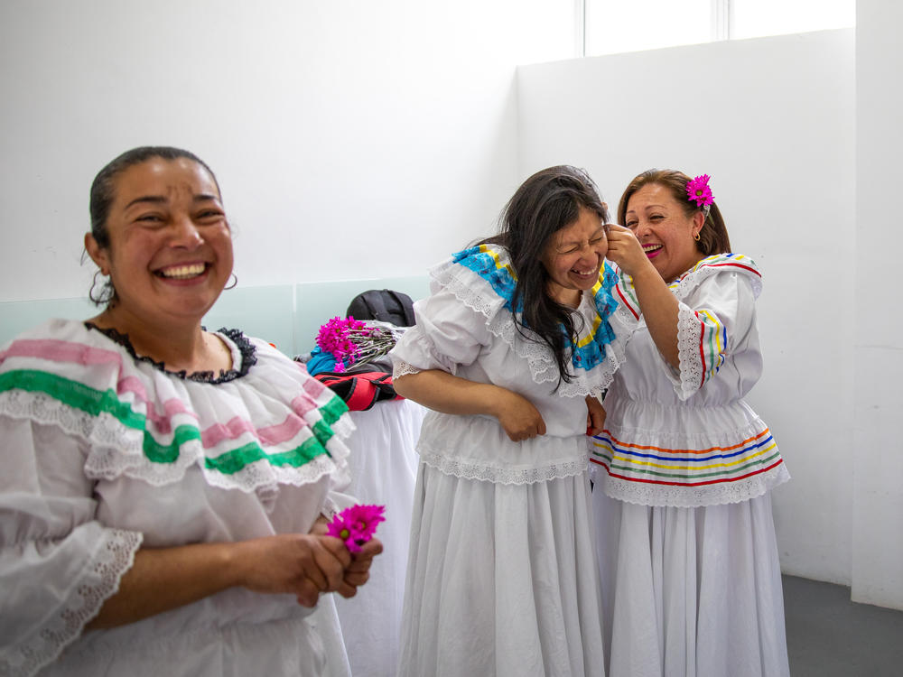 Ruth Infante (second from left), a single mother of three, and her classmates donned traditional flowing dresses for their <em>Cumbia</em> dance performance at a 