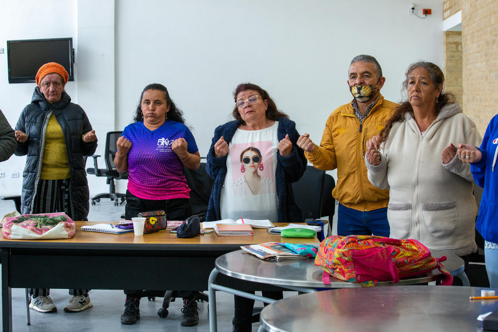 Rita Salamanca (center), 60, stretches and breathes before the start of a science class at the care block in the San Cristobal neighborhood of Bogotá. She's among the more than 12,000 women citywide taking free educational courses offered through the care blocks. She hopes to get her high school diploma.