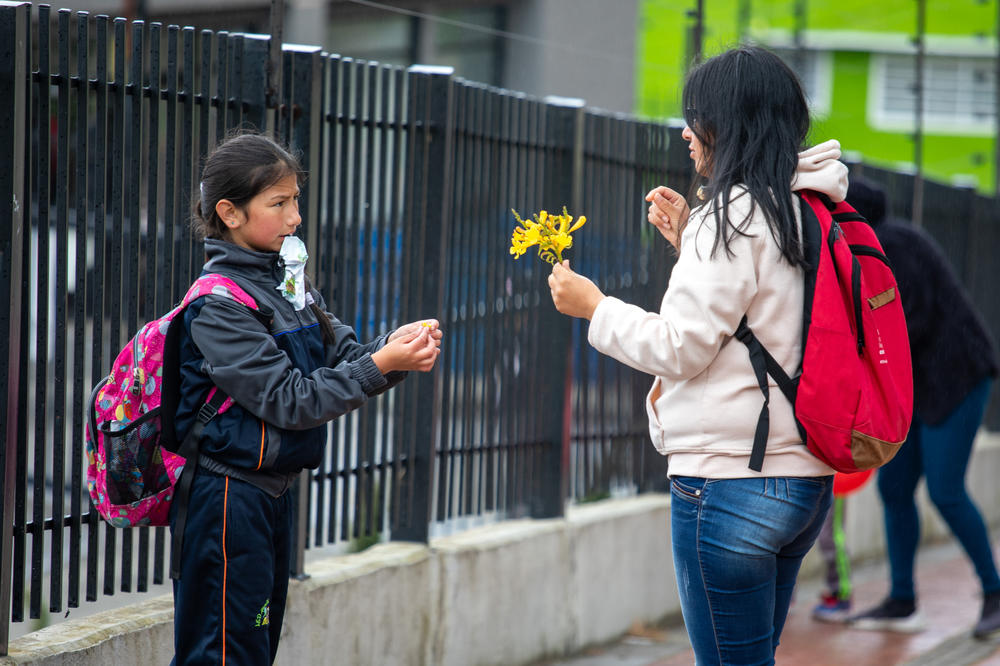 Infante and her 9-year-old daughter, Brigitte, stop to pick flowers on their way home from school. Infante's day starts at 5 a.m. and doesn't end until bedtime.