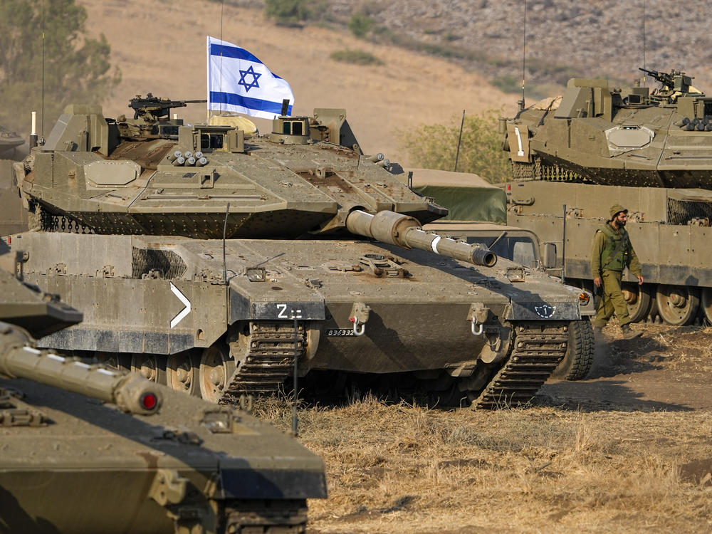 Israeli tanks are stationed near the border with Lebanon on Wednesday. A plurality of Americans say Israel's response to a deadly attack by Hamas has been about right.