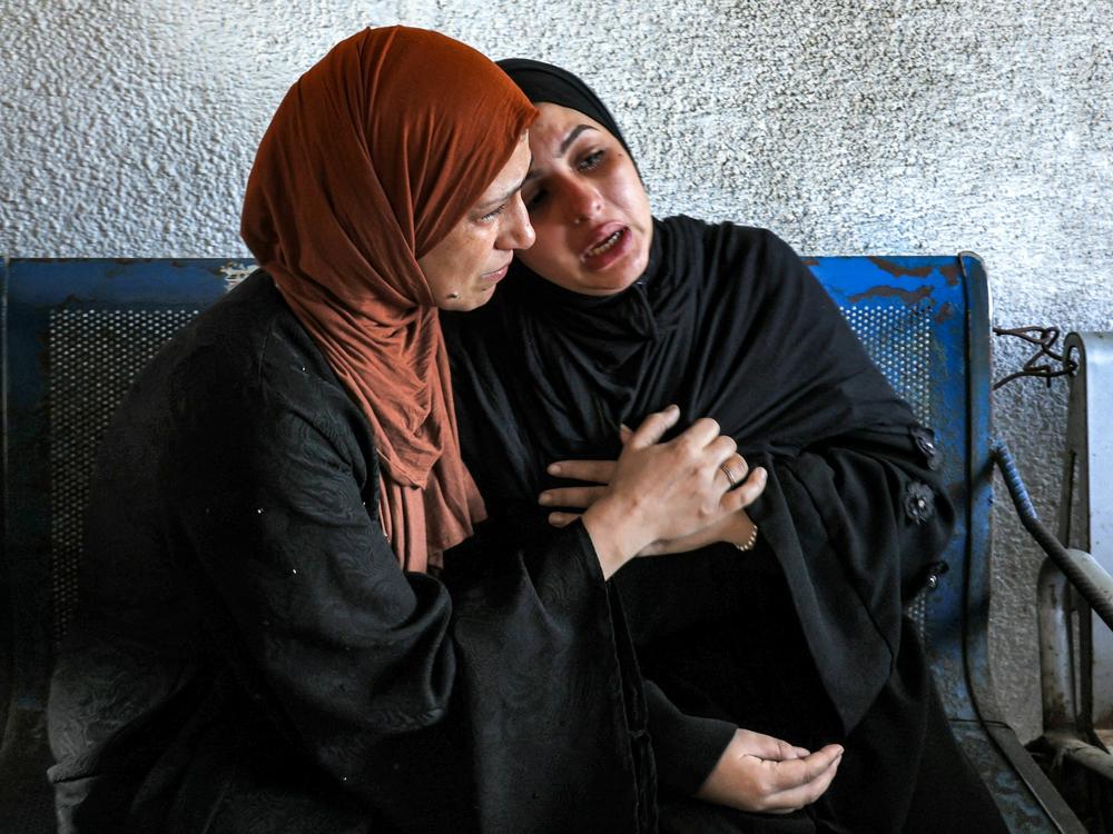 A woman comforts another mourning outside the morgue of al-Shifa hospital in Gaza City on Thursday.