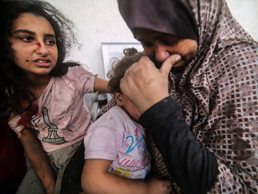 People injured from Israeli air strikes on Oct. 12 wait outside a hospital to be treated. The sheer volume of medical need is overwhelming the small and exhausted number of staff at Gaza's medical facilities, says Dr. Mohammad Mattar, head of the radiology department at Al Shifa Hospital, the Gaza Strip's largest medical complex.