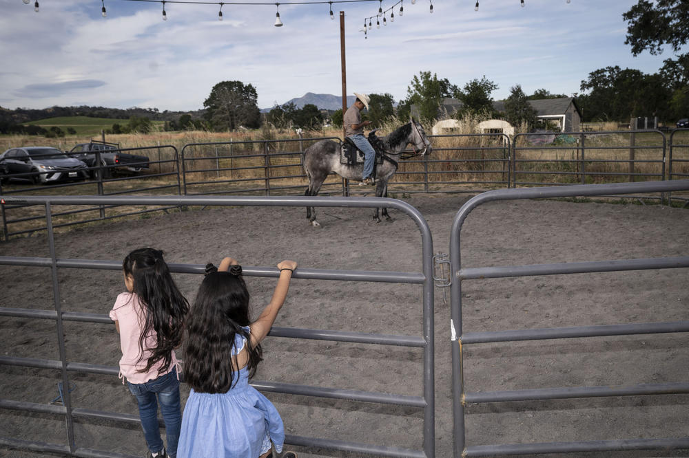 Two girls look on at a horse during Kevin's birthday party in June 2023.