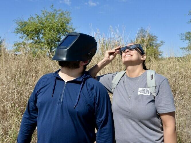 Jonathan Quirarte, left, watched the eclipse with his girlfriend at Phil Hardberger Park in San Antonio. To protect his eyes, Quirarte wore a welder mask he purchased for a previous eclipse.