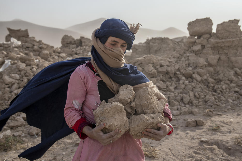 Thurs., Oct. 12: An Afghan woman uses the bricks of her destroyed house to strengthen her tent during a sandstorm, after an earthquake in Zenda Jan district in Herat.