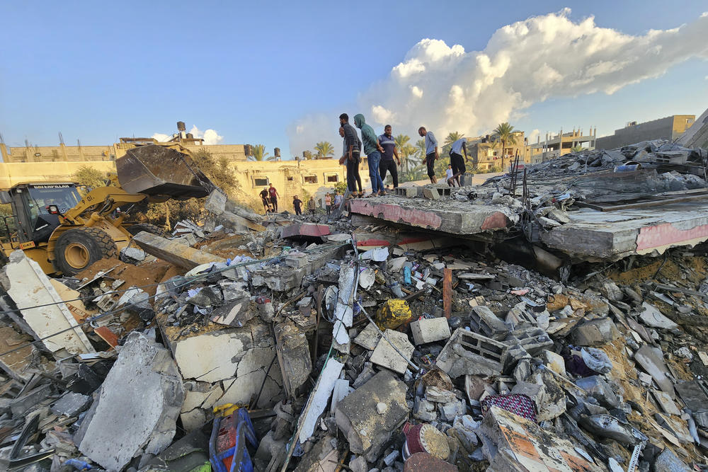 Sun., Oct. 15: Palestinians stand by the rubble of a building destroyed in Israeli airstrikes in Deir el-Balah Gaza Strip.