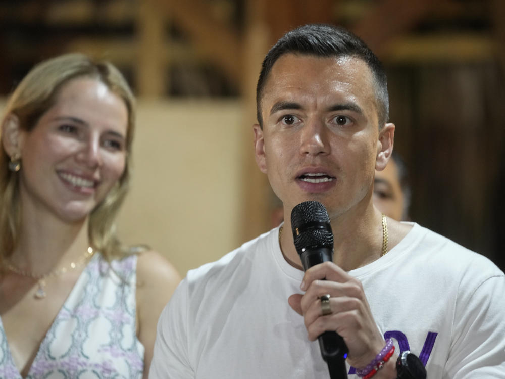 Presidential candidate Daniel Noboa speaks in Olon, Ecuador, after results show him ahead in a snap presidential runoff on Sunday, Oct. 15, 2023. At left is his wife Lavinia Valbonesi.