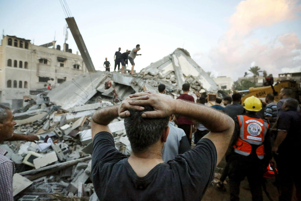 Sun., Oct .15: A man reacts as he watches rescuers and civilians remove the rubble of a home destroyed following an Israeli attack on the town of Deir Al-Balah, in the central Gaza Strip.