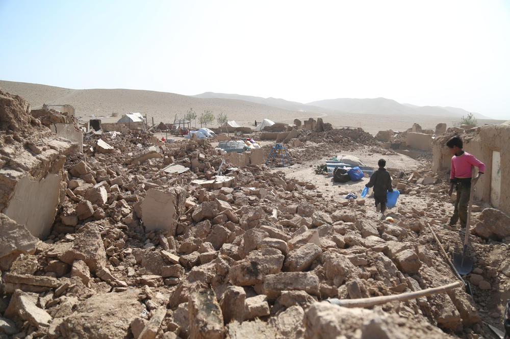 Children walk amid the debris. The earthwaukes on Oct. 7 flattened whole villages in Herat.
