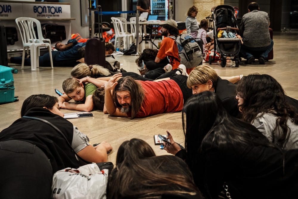 Sun., Oct. 15: Alexander Lenskiy, 38, center, take shelter on the ground with the rest of his family and other travelers as the air raid sirens sound all over Ben Gurion Airport, near Tel Aviv, Israel