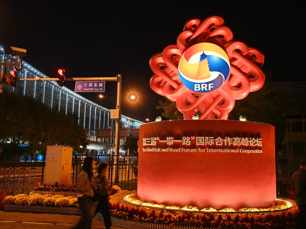 People walk past a decorative installation for the third Belt and Road Forum for International Cooperation on Sunday in Beijing.