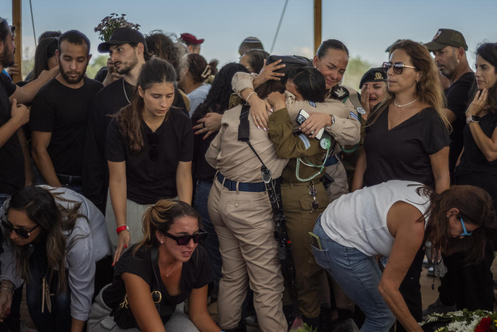 People mourn as they attend the burial and funeral of five Kutz family members in Israel. Aviv, 54 years old, Livnat, 49 years old, Rotem, 19 years old, Yonatan, 17 years old, and Yiftach, 15 years old, were murdered in their home by Palestinian militants who infiltrated into the Israeli Kibbutz of Kfar Aza last week.