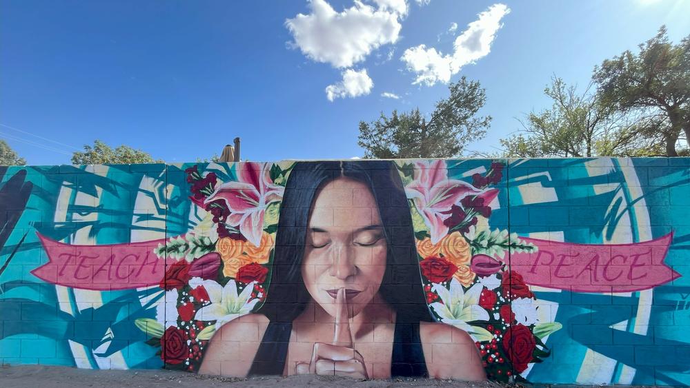 Outside the public library in Albuquerque's International District is a memorial mural for victims of shootings. Local police call the neighborhood the 