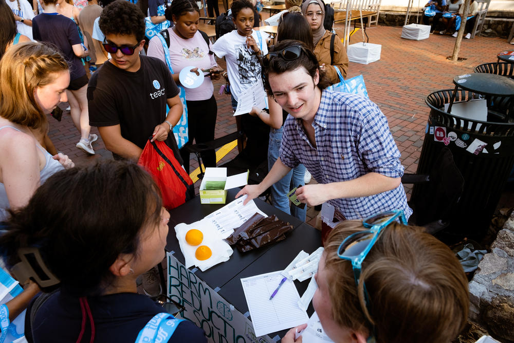 Students Riley Sullivan (center) and Callan Baruch (left) co-founded the Carolina Harm Reduction Union along with Caroline Clodfelter. At a campus event at the University of North Carolina at Chapel Hill this fall, the group handed out naloxone injection kits.