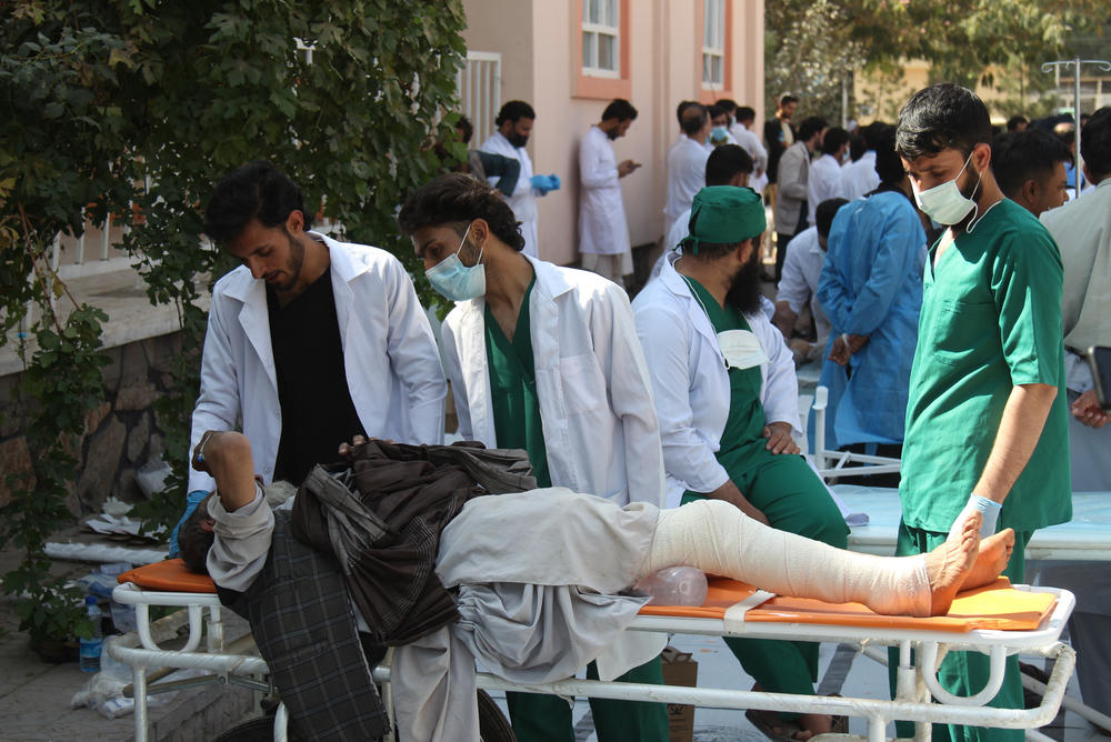 Doctors and paramedics treat injured earthquake survivors in front of the Herat Regional Specialized Hospital.
