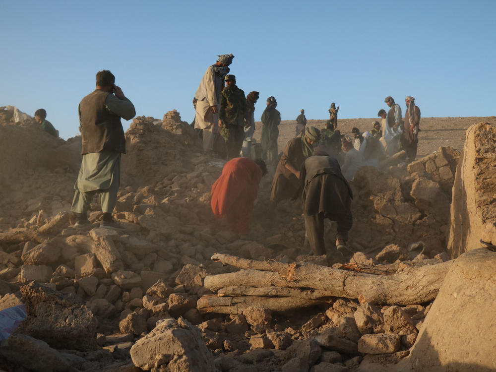 Afghan residents clear debris from a damaged house after an earthquake in the Zendeh Jan district of Herat province on Oct. 7.