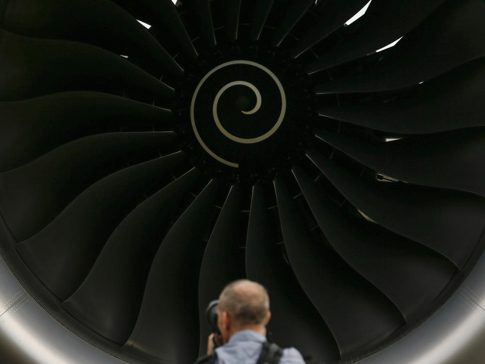 A visitor takes a photo of the Rolls-Royce jet engine of the Airbus A350-1000 parked at the static display area during the Singapore Airshow on Feb. 7, 2018, in Singapore.