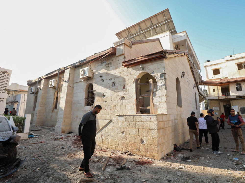 People inspect the damage at Al Ahli Arab Hospital in central Gaza on Wednesday, following a strike which killing hundreds on Tuesday.