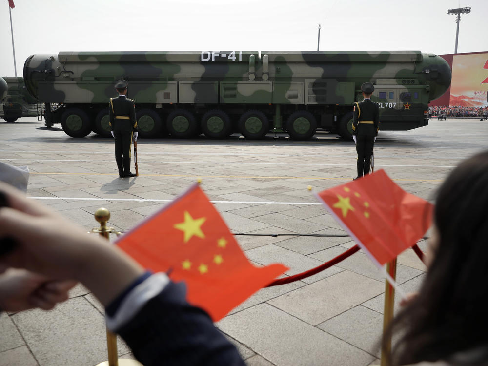 Spectators wave Chinese flags as military vehicles carrying DF-41 ballistic missiles roll during a parade to commemorate the 70th anniversary of the founding of Communist China in Beijing, Oct. 1, 2019. The latest assessment from the defense department said China had increased its arsenal of operational nuclear warheads from the estimated 400 in 2021 to more than 500 as of May this year.
