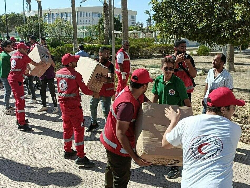 Workers load the trucks with boxes after a planes carrying Turkish humanitarian aid for residents of the Gaza Strip landed at El Arish International Airport in Egypt, neighboring the enclave under intense Israeli blockade and bombardment on October 13, 2023.