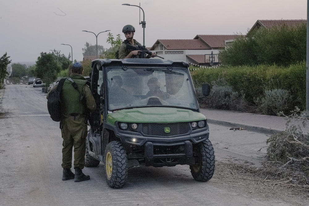 Soldiers patrol the destroyed neighborhood.