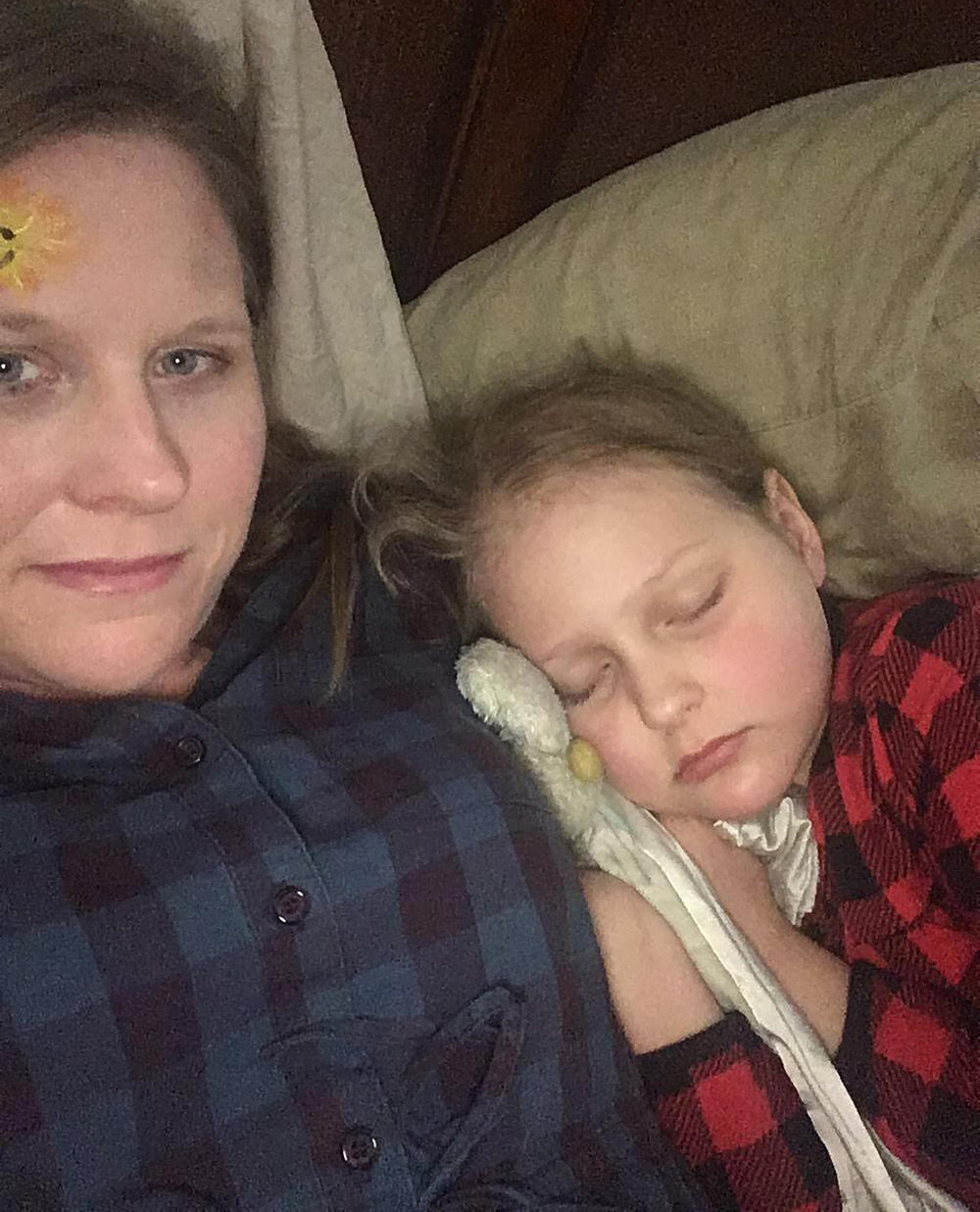 Laura Bray and her daughter, Abby, resting after one of Abby's leukemia treatments in May 2019.